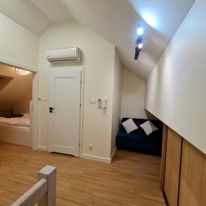 a small room with a door and a bed at Apartament Mierzeja LUX Baltic Garden in Sztutowo