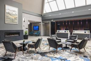 a lobby with chairs and tables and a fireplace at Delta Hotels by Marriott Calgary South in Calgary