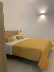 una camera da letto con un grande letto con una coperta gialla di B&B LA FONTANA a Mattinata