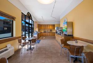 a restaurant with tables and chairs and a kitchen at Best Western Plains Motel in Wall