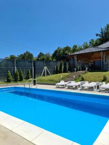 a swimming pool with chairs and a house at House_Zoi in Čelinac