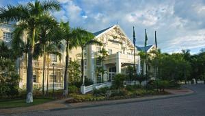 una grande casa bianca con palme di fronte di Southern Sun Mbombela a Nelspruit