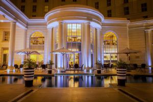 a lobby with a large building with tables and umbrellas at Southern Sun The Cullinan in Cape Town