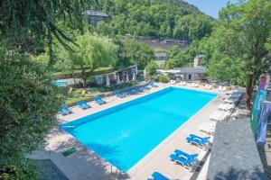 uma vista sobre uma piscina com espreguiçadeiras e árvores em Hotel & Aparthotel Cosmos em Andorra-a-Velha