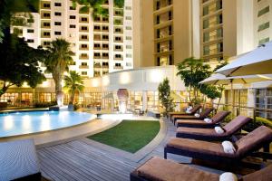 a hotel lobby with a pool and chairs and buildings at Southern Sun Waterfront Cape Town in Cape Town