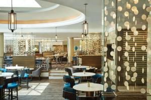 a restaurant with tables and chairs and a bar at Southern Sun Waterfront Cape Town in Cape Town