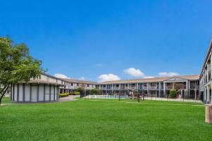 une vue sur l'extérieur d'une école avec une pelouse verte dans l'établissement Rodeway Inn Conference Center, à Beaumont