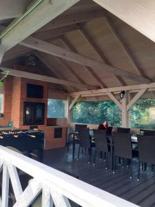 a dining area with a table and chairs on a deck at Agroturystyka Jagodowa Róża in Mszana Dolna
