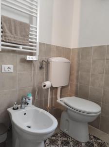 a bathroom with a white toilet and a sink at La Casina in Fornello