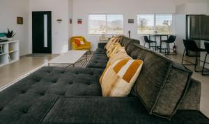 ein Wohnzimmer mit einem Sofa mit Kissen darauf in der Unterkunft Coyote Tracks - A Modern Desert Experience in Joshua Tree