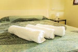 three towels are on top of a bed at Confortevole appartamento per due con servizi inclusi in Agropoli