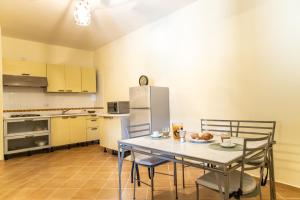 a kitchen with a table and chairs and a refrigerator at Confortevole appartamento per due con servizi inclusi in Agropoli