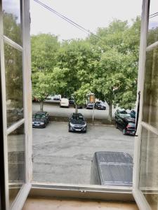 a window view of a parking lot with cars parked at Villa Elda in Saint-Jean-dʼAngély