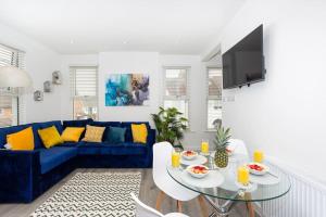 a living room with a blue couch and a table at 2 bed apartment near the beach in Southend-on-Sea