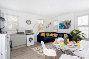 - un salon avec une table et un canapé bleu dans l'établissement 2 bed apartment near the beach, à Southend-on-Sea