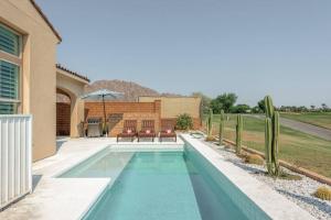 einen Pool mit Stühlen und ein Haus in der Unterkunft Stylish Luxury Signature PGA with Private Pool & Golf Cart. LIC# 259358 - 4 Bedrooms in La Quinta