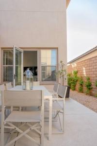 einen weißen Esstisch und Stühle auf einer Terrasse in der Unterkunft Stylish Luxury Signature PGA with Private Pool & Golf Cart. LIC# 259358 - 4 Bedrooms in La Quinta