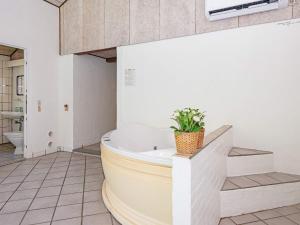 a bathroom with a tub and a plant in it at 14 person holiday home in rsted in Kare