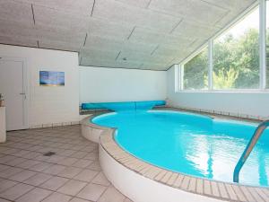 a large swimming pool in a room with a large window at 14 person holiday home in rsted in Kare