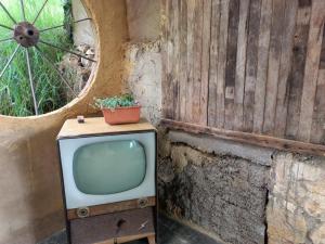 una vieja TV sentada junto a una pared de piedra en ¡Habitación en un Bus!, en La Calera