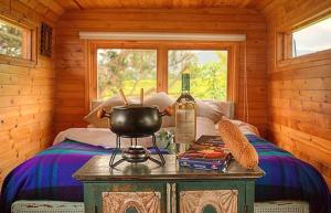 Habitación con una cama con una botella de vino y una mesa en ¡Habitación en un Bus!, en La Calera