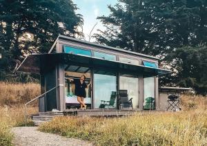a woman standing in the front of a tiny house at Pōhue PurePod in Purau
