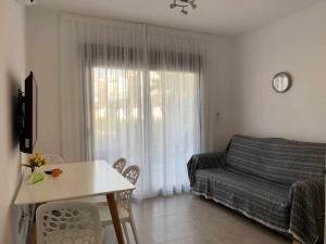 - un salon avec un lit, une table et une fenêtre dans l'établissement Hermoso estudio en Pilar de la Horadada, à Pilar de la Horadada