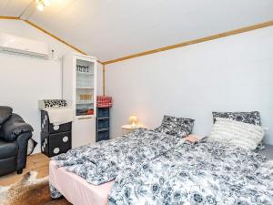 StubbekøbingにあるTwo-Bedroom Holiday home in Stubbekøbing 1のベッドルーム1室(ベッド1台、椅子付)