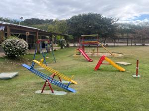 a park with a playground with a slide at Flat Polaris - Condomínio Village - Aldeia das Águas in Barra do Piraí