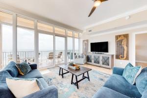 a living room with blue couches and a tv at Phoenix Gulf Shores in Gulf Shores