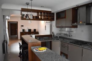 a kitchen with wooden cabinets and a counter top at Refugio Andino in Malargüe