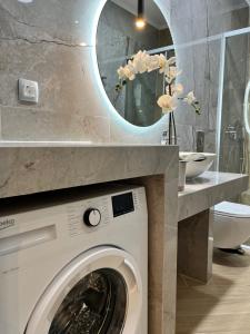 a bathroom with a washing machine and a mirror at Maison deluxe studios and apartment in Parga +76 photos