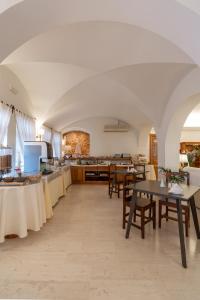 a dining room with tables and a kitchen at Hotel Matina in Kamari