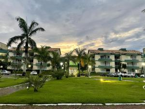 un parque frente a un edificio con palmeras en Polaris Flat - Aldeia das Águas Park Resort en Barra do Piraí