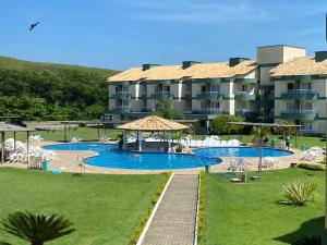 a resort with a swimming pool and a large building at Flat Polaris - Condomínio Village - Aldeia das Águas in Barra do Piraí