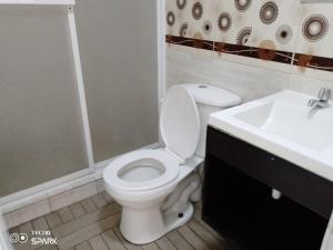 un bagno con un water bianco e un lavandino di HOSPEDAJE YACUCALLE a Ibarra