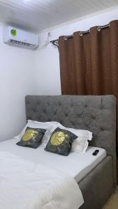 a bed with two pillows on top of it at Deluxe Mansion in Buea