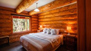 1 dormitorio con 1 cama en una cabaña de madera en Cascade Creek Retreat, en Milton