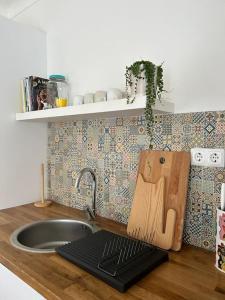 a kitchen counter with a sink and a cutting board at Casa dos Avós in Vila Nova de Milfontes