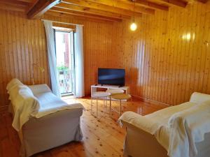 a living room with two beds and a television at A Casa De Regina in Malpica