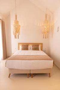 a bedroom with a large bed with two chandeliers at Alux Boutique Hotel in Málaga