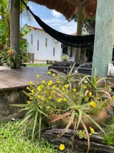 un giardino con fiori gialli di fronte a una casa di Casa Bali 1 2 3 a Niterói