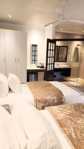 a hotel room with two beds and a bathroom at Rest&Relax Guesthouse in Johannesburg