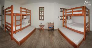 a room with two bunk beds and a wooden floor at Hotel On The Rock in Minca