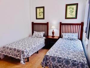 een slaapkamer met 2 bedden en een tafel met een lamp bij Vista al Mar Fuerteventura in Puerto del Rosario