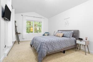ein weißes Schlafzimmer mit einem Bett und einem Fenster in der Unterkunft Gorogeous Chic 2BDR Renovated Home near Downtown Sleeps 6 843 in Traverse City