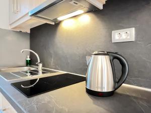 a tea kettle on a kitchen counter next to a sink at Maison deluxe studios and apartment in Parga