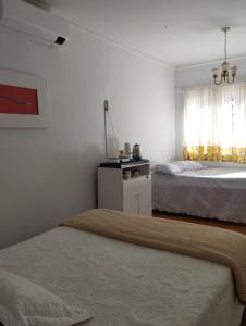 a bedroom with two beds and a window at Pousada Guaíra in Guaíra