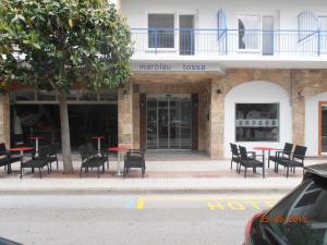 a group of tables and chairs in front of a building at Hotel Marblau Tossa in Tossa de Mar