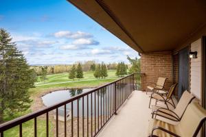 d'un balcon avec des chaises et une vue sur un parcours de golf. dans l'établissement Lakeview Golf Retreat 1BDR Condo at Resort 5057, à Traverse City